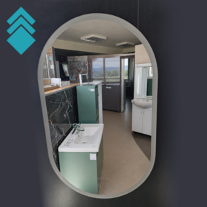 Arched mirror reflecting a bathroom showroom with sinks, cabinets, and tile displays on the showroom floor.