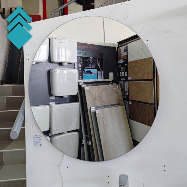 Showroom display of bathroom fixtures with stacked white water tanks and tile samples framed by a circular cutout.
